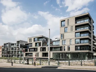 Hand-Made miniature green grey facing brick makes the building stand out thanks to its texture and colour